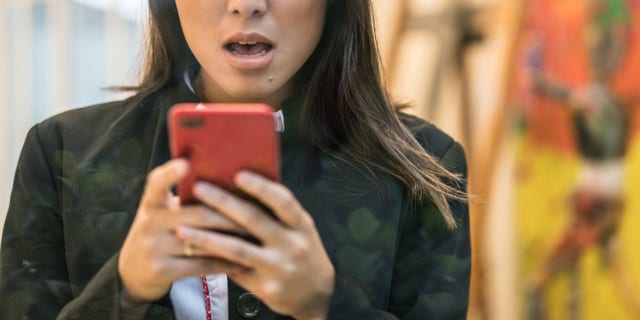 Business Woman worried about the news on her mobile phone