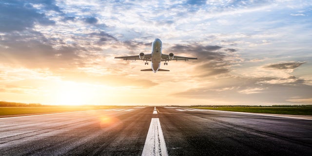 Airplane Taking Off with sunrise behind it