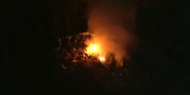 Fire is seen in the area where a helicopter crashed Tuesday near an airport in Leesburg, Florida.