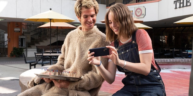 This image released by IFC Films shows Andrew Garfield, left, and Maya Hawke in a scene from "Mainstream," a film by Gia Coppola.