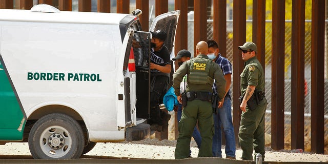 Asylum-seeking migrants are taken to a van after they crossed into El Paso, Texas, U.S., and turned themselves in to U.S. Border Patrol agents to request asylum, as seen from Ciudad Juarez, Mexico May 14, 2021. REUTERS/Jose Luis Gonzalez
