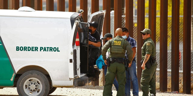 Asylum-seeking migrants are taken to a van after they crossed into El Paso, Texas, U.S., and turned themselves in to U.S. Border Patrol agents to request asylum, as seen from Ciudad Juarez, Mexico May 14, 2021. REUTERS/Jose Luis Gonzalez