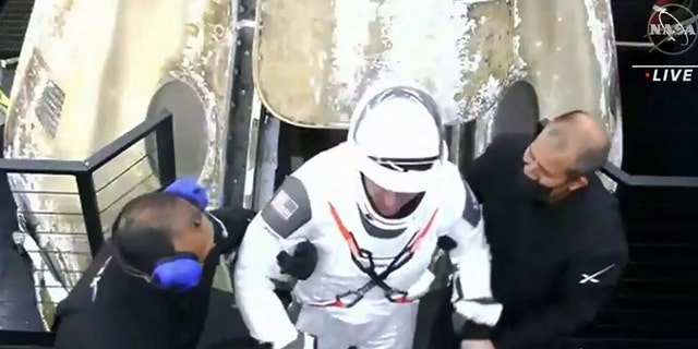 A crew member steps out of the capsule after it parachuted into the Gulf of Mexico off the coast of Panama City, Florida, just before 3 a.m. returning from the International Space Station. 