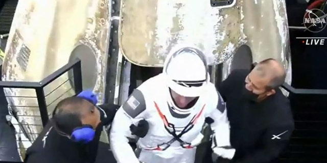 A crew member steps out of the capsule after it parachuted into the Gulf of Mexico off the coast of Panama City, Florida, just before 3 a.m. returning from the International Space Station.