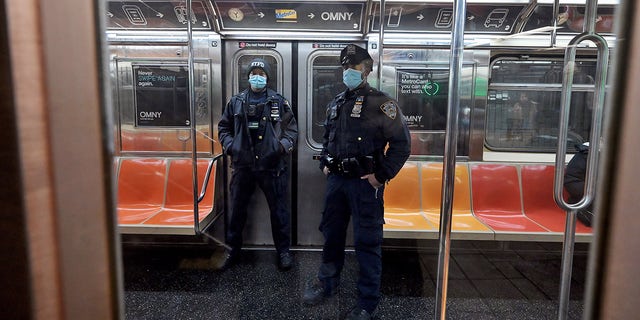 Two NYPD officers patrol the subways as violent crime continues to rise. 