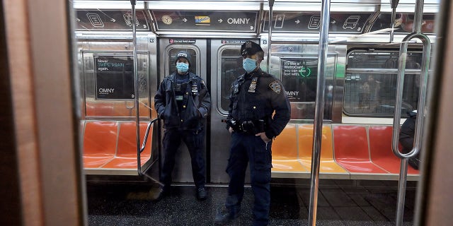 Two NYPD officers patrol the subways as violent crime continues to rise.