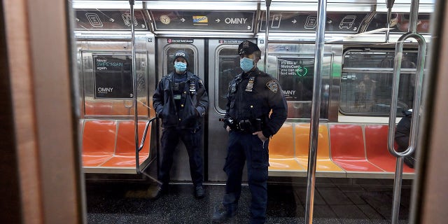 Two NYPD officers patrol the subways as violent crime continues to rise. 