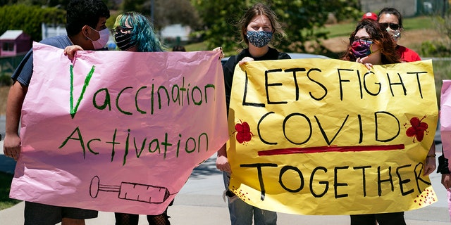 May 24, 2021: San Pedro High School students hold vaccination signs at a school-based COVID-19 vaccination event for students 12 and older in San Pedro, Calif.