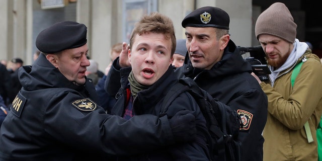 FILE - In this Sunday, March 26, 2017 file photo, Belarus police detain journalist Raman Pratasevich, center, in Minsk, Belarus. Raman Pratasevich, a founder of a messaging app channel that has been a key information conduit for opponents of Belarus’ authoritarian president, has been arrested after an airliner in which he was riding was diverted to Belarus because of a bomb threat. The presidential press service said President Alexander Lukashenko personally ordered that a MiG-29 fighter jet accompany the Ryanair plane — traveling from Athens, Greece, to Vilnius, Lithuania — to the Minsk airport. ﻿﻿(AP Photo/Sergei Grits, File)
