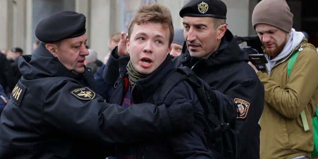 FILE - In this Sunday, March 26, 2017 file photo, Belarus police detain journalist Raman Pratasevich, center, in Minsk, Belarus. Raman Pratasevich, a founder of a messaging app channel that has been a key information conduit for opponents of Belarus’ authoritarian president, has been arrested after an airliner in which he was riding was diverted to Belarus because of a bomb threat. The presidential press service said President Alexander Lukashenko personally ordered that a MiG-29 fighter jet accompany the Ryanair plane — traveling from Athens, Greece, to Vilnius, Lithuania — to the Minsk airport. (AP Photo/Sergei Grits, File)