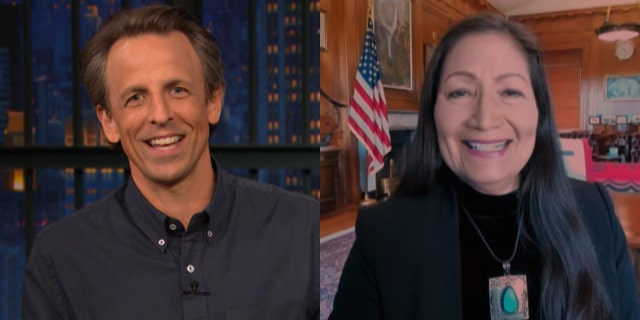 Comedian Seth Meyers called out a Deb Haaland staffer when he caught the cameraman crawling on the floor in the background during a Tuesday interview on ‘Late Night with Seth Meyers.’