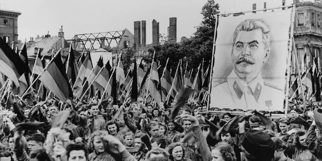 1950年6月1日，苏联在德国柏林的Lustgarten举行的青年集会。这些年轻人举着约瑟夫·斯大林（Joseph Stalin）等共产主义领导人的巨幅肖像（如图）。