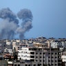 Smoke rises following Israeli airstrikes on a building in Gaza City, Thursday, May 13, 2021. Israeli airstrikes killed multiple senior Hamas military figures Wednesday and toppled a pair of high-rise towers housing Hamas facilities. (AP Photo/Hatem Moussa)