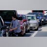 A customer pumps gas at Costco, as others wait in line, on Tuesday, May 11, 2021, in Charlotte, North Carolina. Gasoline futures are ticking higher following a cyberextortion attempt on the Colonial Pipeline, a vital U.S. pipeline that carries fuel from the Gulf Coast to the Northeast.