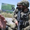 Israeli soldiers hold positions at Netiv Ha'Asara near the site where an IDF vehicle was directly hit by a rocket fired from Gaza strip, injuring two and killing one, in Netiv Ha'Asara. May 12, 2021. (Gili Yaari/NurPhoto via Getty Images)