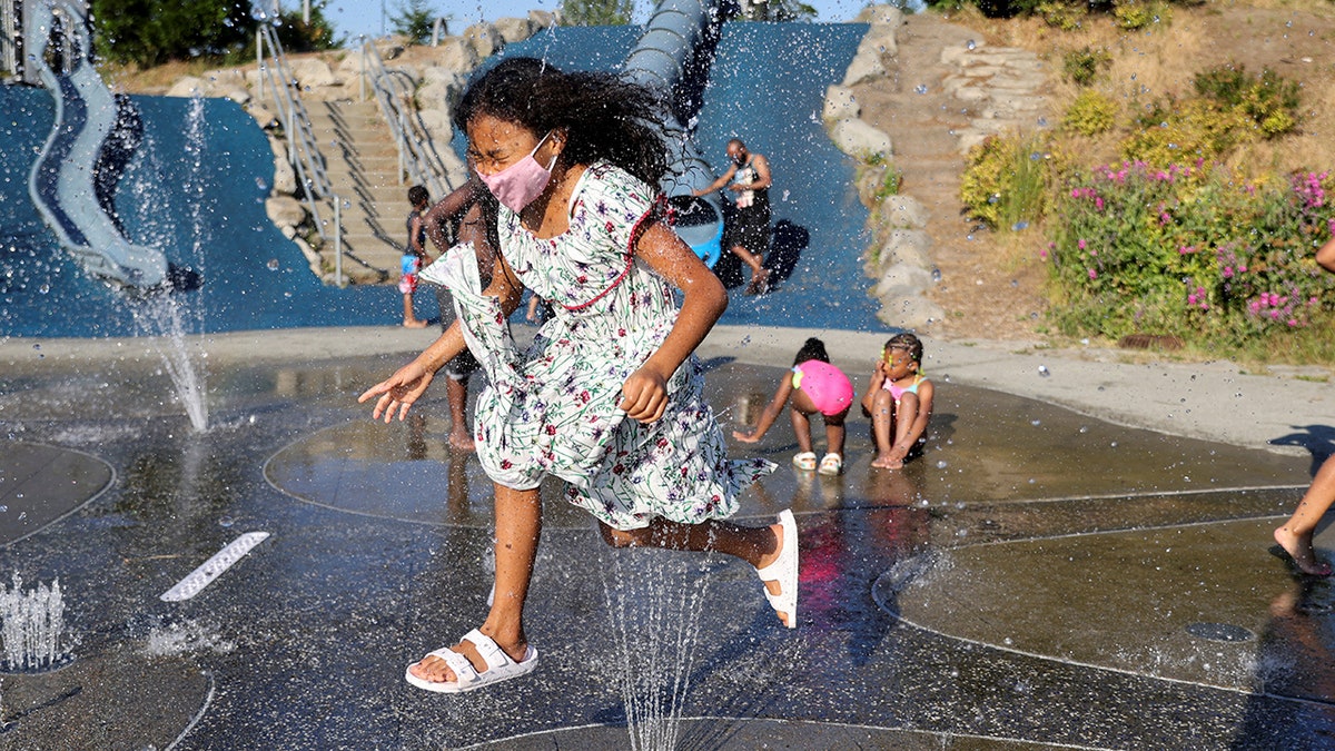 Isis Macadaeg, age 7, plays in a spray park at Jefferson Park during a heat wave in Seattle, Washington, U.S., on June 27, 2021. REUTERS/Karen Ducey