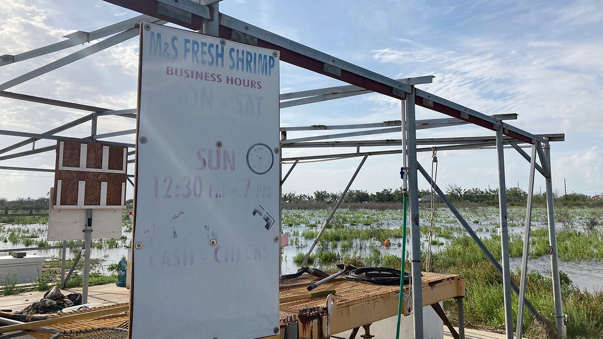 A weathered sign advertises fresh shrimp from a stand owned by Shirley Gray and her husband in Cameron, La. Hurricane Laura last year destroyed one of their boats, heavily damaged another and destroyed much of their equipment. (AP Photo/Rebecca Santana)