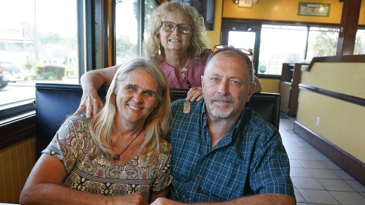 Two days after Debby-Neal Strickland (front left) and Jim Strickland were married in November, Debby donated a kidney to her husband's ex-wife, Mylaen Merthe (center back). (AP Photo/John Raoux)