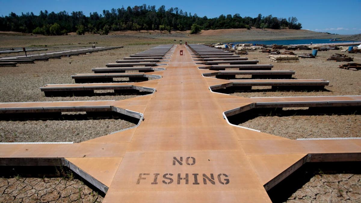 Empty boat docks sit on dry land at the Browns Ravine Cove area of drought-stricken Folsom Lake in Folsom, California, Saturday, May 22, 2021. (Associated Press)