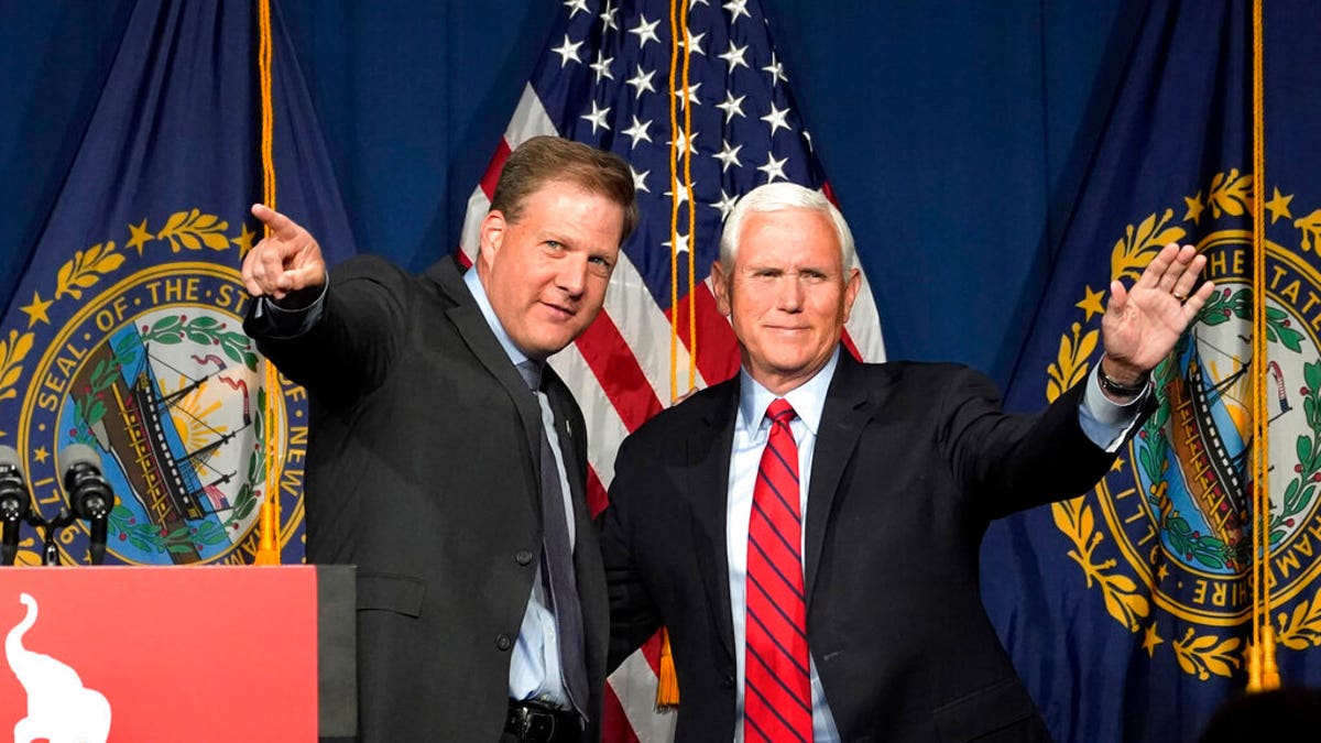 Former Vice President Mike Pence, right, waves as N.H. Gov. Chris Sununu introduces him at the annual Hillsborough County NH GOP Lincoln-Reagan Dinner, Thursday, June 3, 2021, in Manchester, N.H. (AP Photo/Elise Amendola)