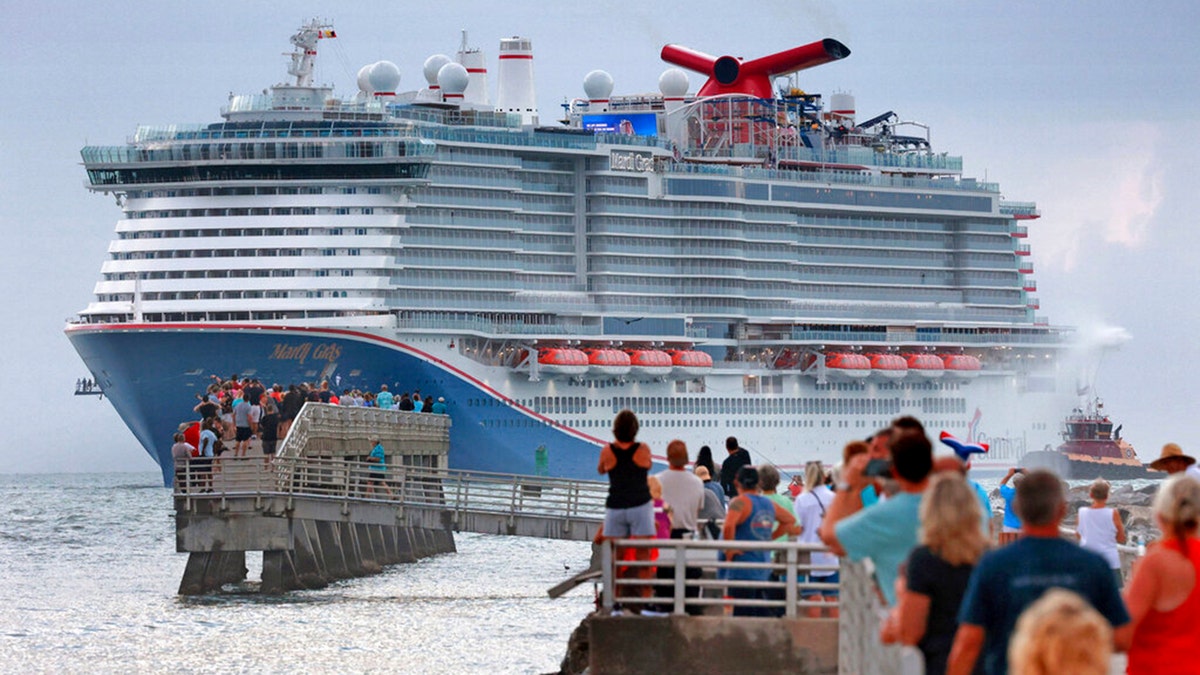 Fans line up at Jetty Park to see the Carnival Cruise Line ship Mardi Gras arrive at Port Canaveral, Florida, early Friday morning. (Joe Burbank/Orlando Sentinel via AP)