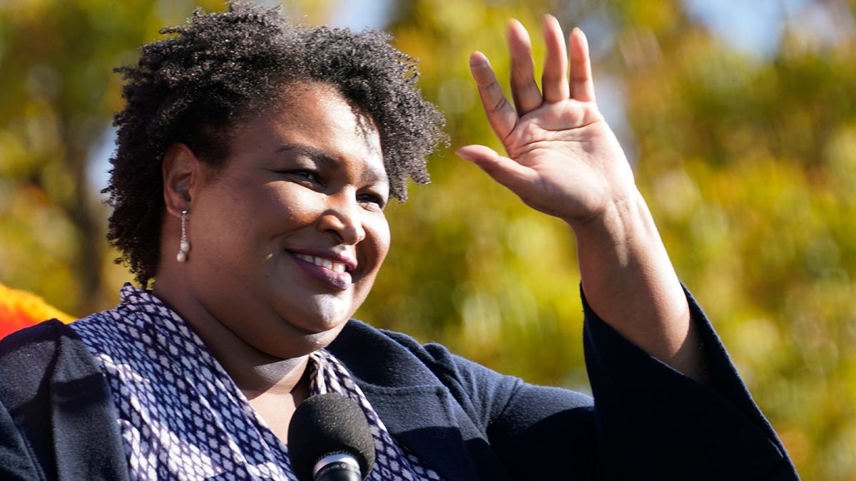 Stacey Abrams speaks to Biden supporters as they wait for former President Obama to arrive and speak at a campaign rally for Biden at Turner Field in Atlanta. 