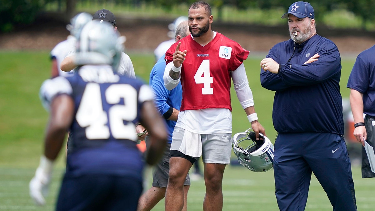 Dallas Cowboys quarterback Dak Prescott (4) stands with head coach Mike McCarthy as they watch drills during an NFL football team practice Tuesday, June 8, 2021, in Frisco, Texas. (AP Photo/LM Otero)