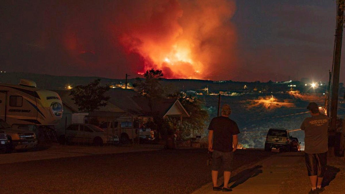 In this photo provided by Joseph Pacheco, a wildfire is seen burning in Globe, Ariz., on Monday, June 7, 2021. Firefighters in Arizona were fighting Tuesday to gain a foothold into a massive wildfire, one of two that has forced thousands of evacuations in rural towns and closed almost every major highway out of the area. (Joseph Pacheco via AP)