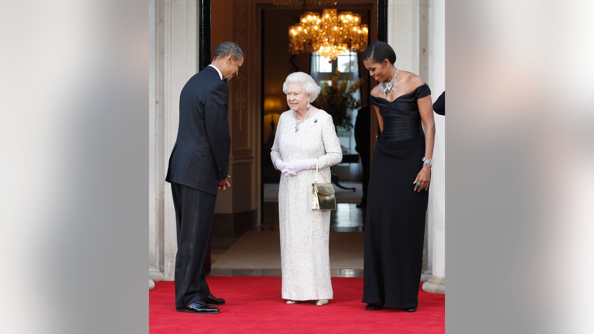 In this May 25, 2011, file photo, U.S. President Barack Obama and first lady Michelle Obama welcome Queen Elizabeth II for a reciprocal dinner at Winfield House in London. (AP Photo/Charles Dharapak, File)