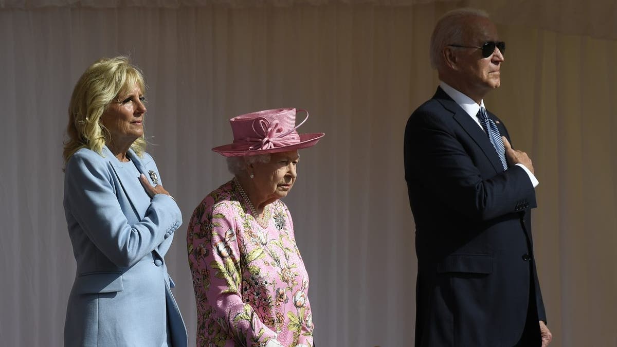 Queen Elizabeth II stands with President Biden and first lady Jill Biden as they listen to the U.S. national anthem at Windsor Castle near London, June 13, 2021.