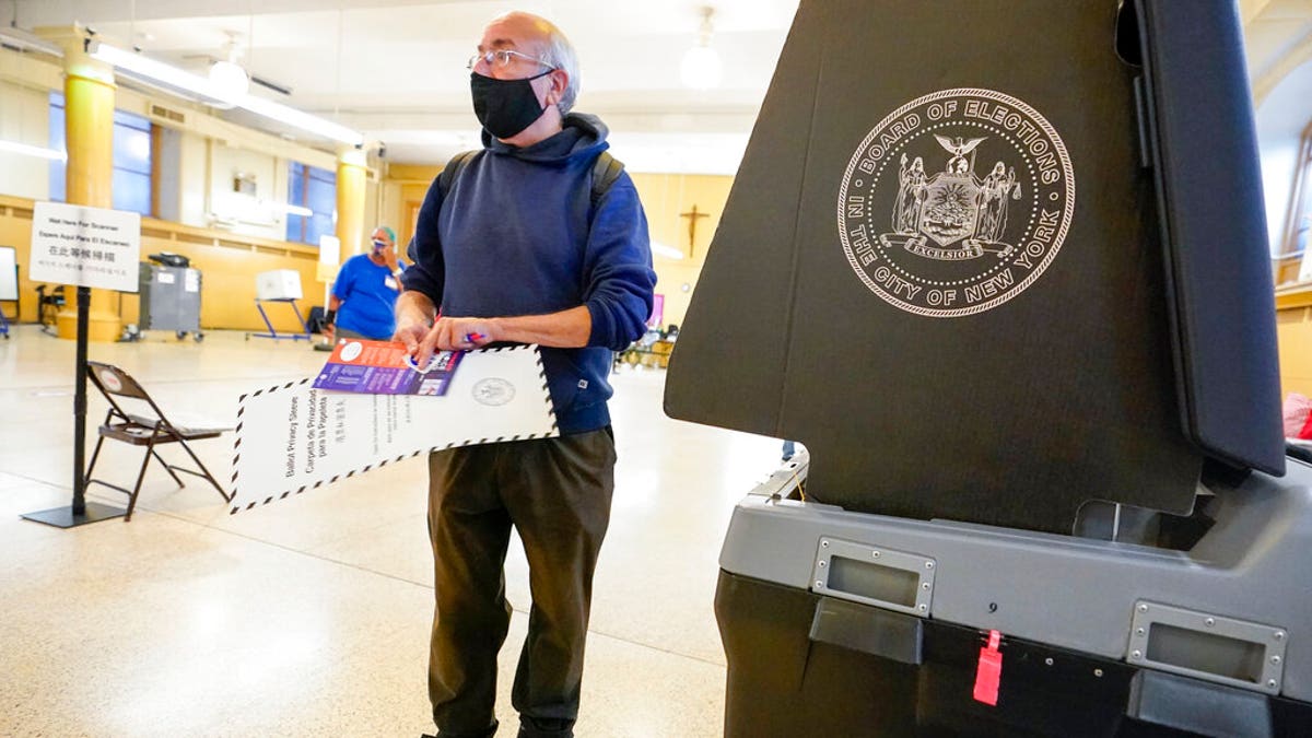 Rafael Risember, 62, prepares to scan his ballot as he participates in early voting in the primary election, Monday, June 14, 2021, at the Church of St. Anthony of Padua in the Soho neighborhood of New York. (AP Photo/Mary Altaffer)