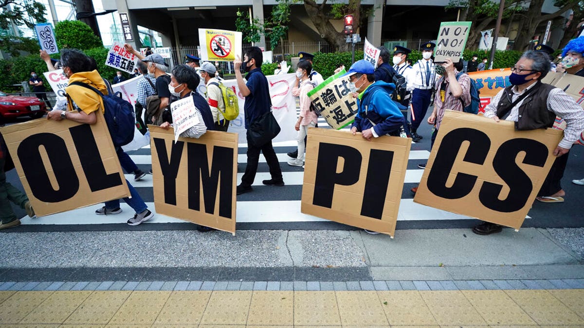 FILE: People who are against the Tokyo 2020 Olympics set to open in July, march to protest around Tokyo's National Stadium during an anti-Olympics demonstration.