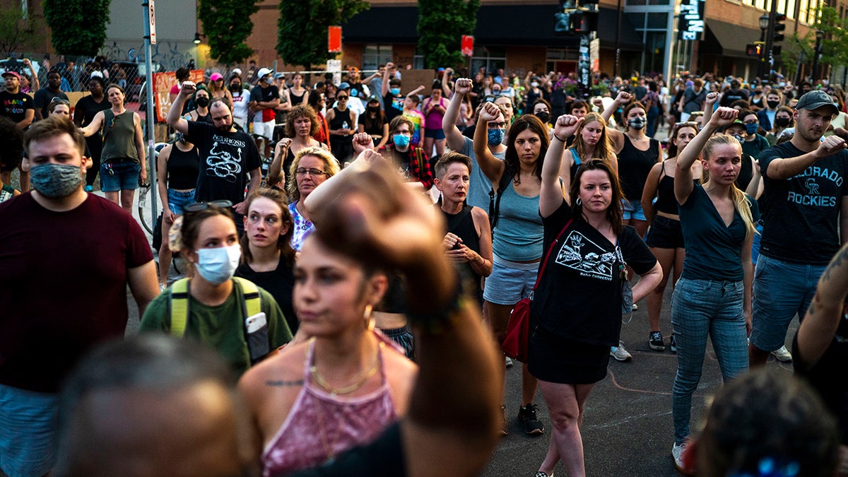Protesters raise their fists in support during a birthday celebration and protest on West Lake Street in Uptown in honor of Deona Marie Knajdek's birthday on Wednesday, June 16, 2021, in Minneapolis. (Antranik Tavitian/Star Tribune via AP)