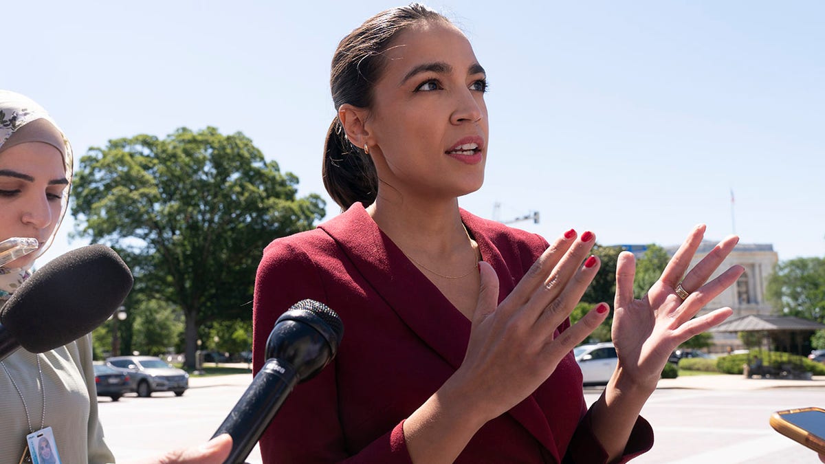 Rep. Alexandria Ocasio-Cortez speals with reporters.