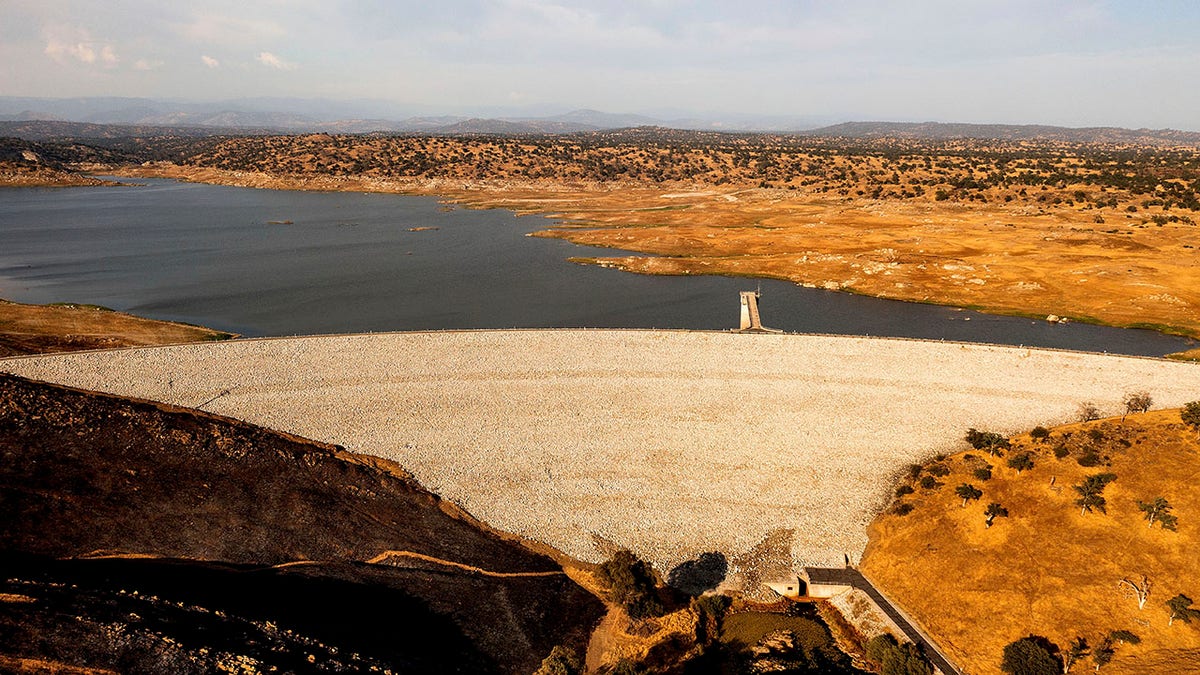 Buchanan Dam holds back water in Eastman Lake on Thursday, June 17, 2021, in unincorporated Madera County, Calif. At the time of this photo, the reservoir was at 11 percent of capacity and 20 percent of its historical average. (AP Photo/Noah Berger)