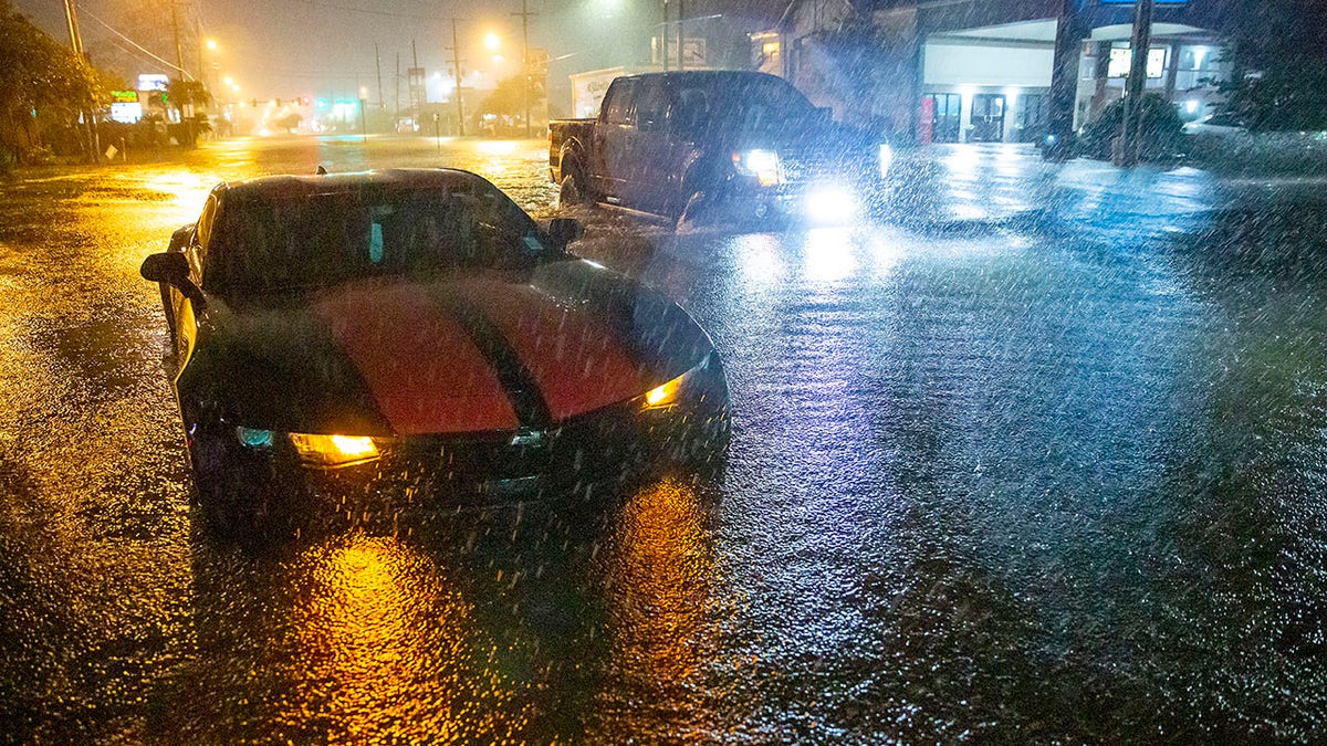 Motorists navigate a flooded Gause Boulevard in Slidell, La., late Friday, June 18, 2021, as a tropical disturbance neared the Louisiana shore. Tropical Storm Claudette has formed Saturday morning along the U.S. Gulf Coast, bringing heavy rains and flooding to coastal states including Louisiana, Mississippi and Alabama.  (Scott Threlkeld/The Advocate via AP)