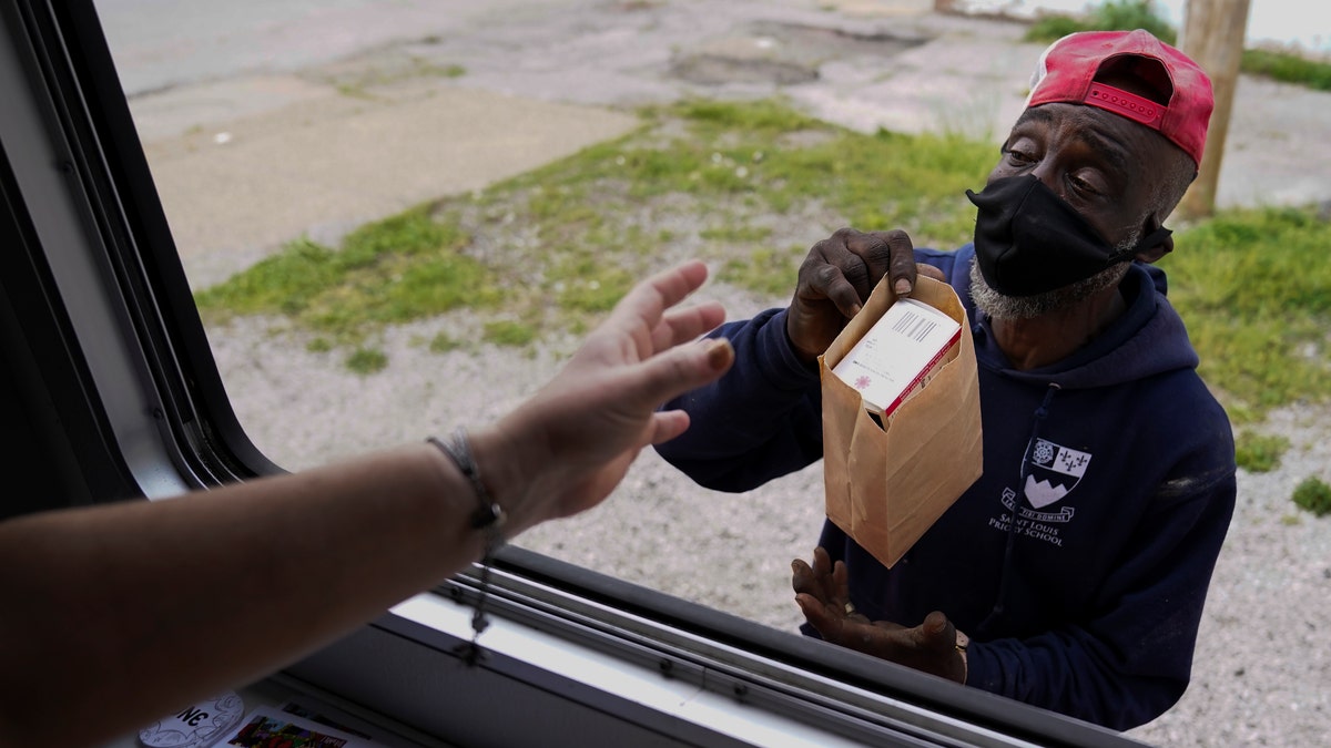 May 21, 2021: A man receives Narcan and other medical supplies from a mobile window during a harm reduction effort in St. Louis.
