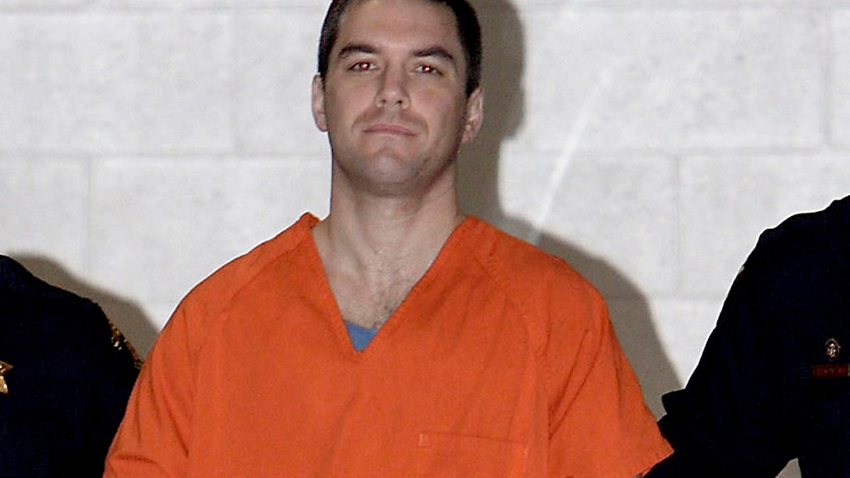 Scott Peterson is escorted by two San Mateo County sheriff's deputies to a waiting van in Redwood City, California, on March 17, 2005. (AP Photo/Justin Sullivan, File)