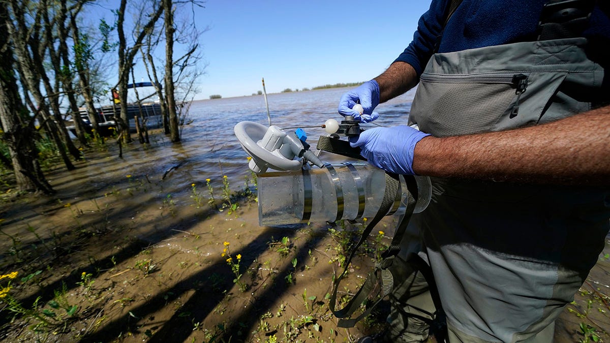 Mike Lamb, co-investigator, of the California Institute of Technology, prepares to take water samples to measure the amount of sediment in the water, in the Wax Lake area of the Atchafalaya River delta system, near Franklin, La., Friday, April 2, 2021. NASA is using high-tech airborne systems along with boats and mud-slogging work on islands for a $15 million study of these two parts of Louisiana's river delta system. (AP Photo/Gerald Herbert)