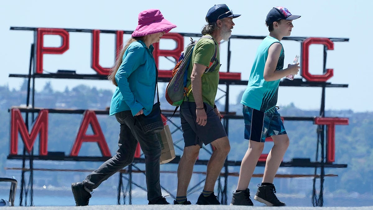 People walk near Pike Place Market, Tuesday, June 29, 2021, in Seattle. (AP Photo/Ted S. Warren)