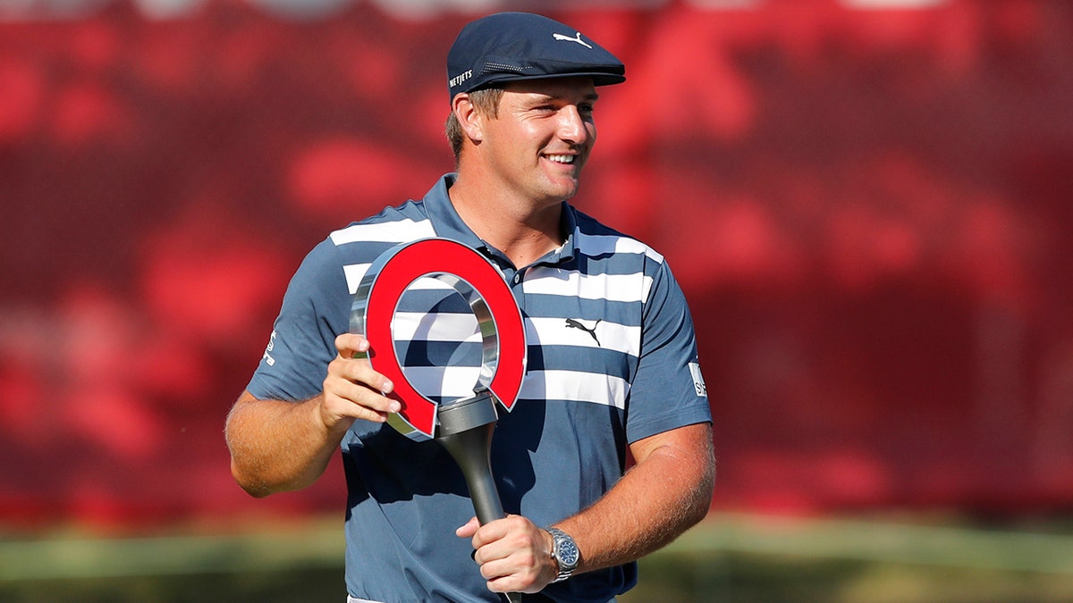 Bryson DeChambeau holds the Rocket Mortgage Classic golf tournament trophy at Detroit Golf Club in Detroit in this July 2020 file photo. (AP Photo/Carlos Osorio, File)