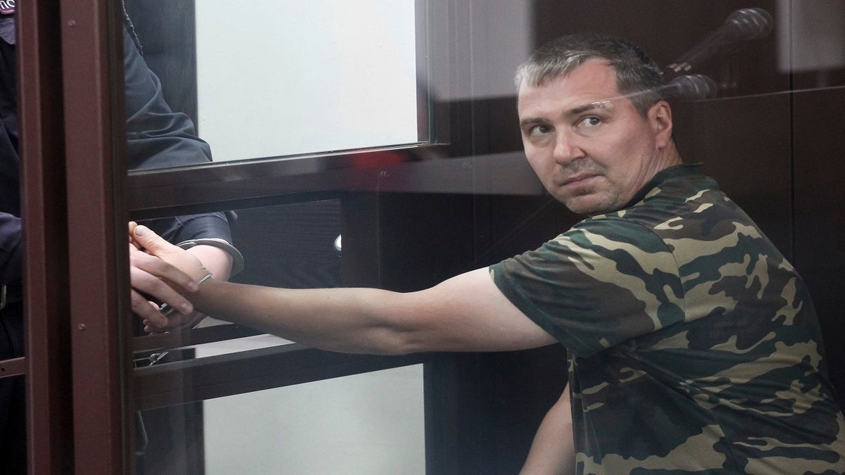 Alexander Popov, a man who was arrested on suspicion of murder sits behind the glass in a courtroom in the city of Gorodets, 36 miles northwest of Nizhny Novgorod, Russia, on Sunday. (AP)