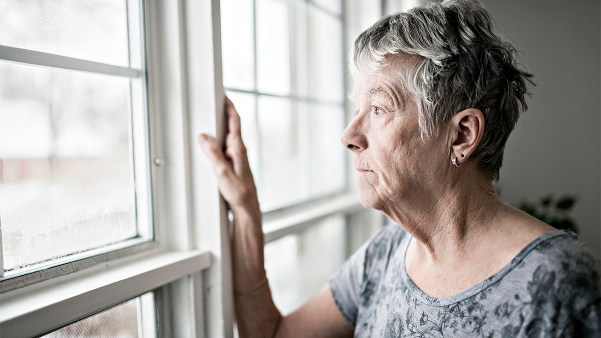 sad and lonely woman at window