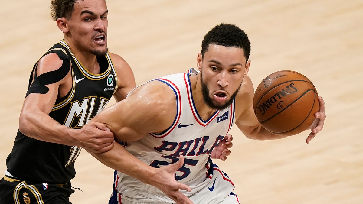 Atlanta Hawks' Trae Young (11) fouls Philadelphia 76ers' Ben Simmons (25) during the first half of Game 4 of a second-round NBA basketball playoff series on Monday, June 14, 2021, in Atlanta.