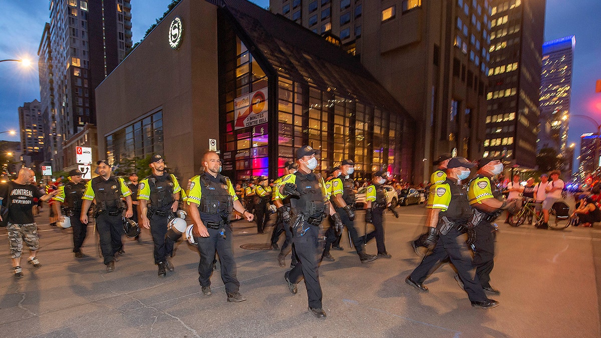 Police move around the Bell Centre, where thousands of Montreal Canadiens fans have assembled for Game 6 of an NHL hockey Stanley Cup semifinal playoff series against the Vegas Golden Knights, in Montreal, Thursday, June 24, 2021. Today is also the provincial holiday of Saint-Jean-Baptiste Day. (Peter McCabe/The Canadian Press via AP)