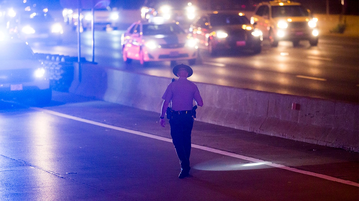 A member of the Illinois State Police looks for evidence on the Eisenhower Expressway where two people were wounded in a shooting Saturday, Aug. 13, 2016, in Chicago. (Armando L. Sanchez/Chicago Tribune/Tribune News Service via Getty Images)