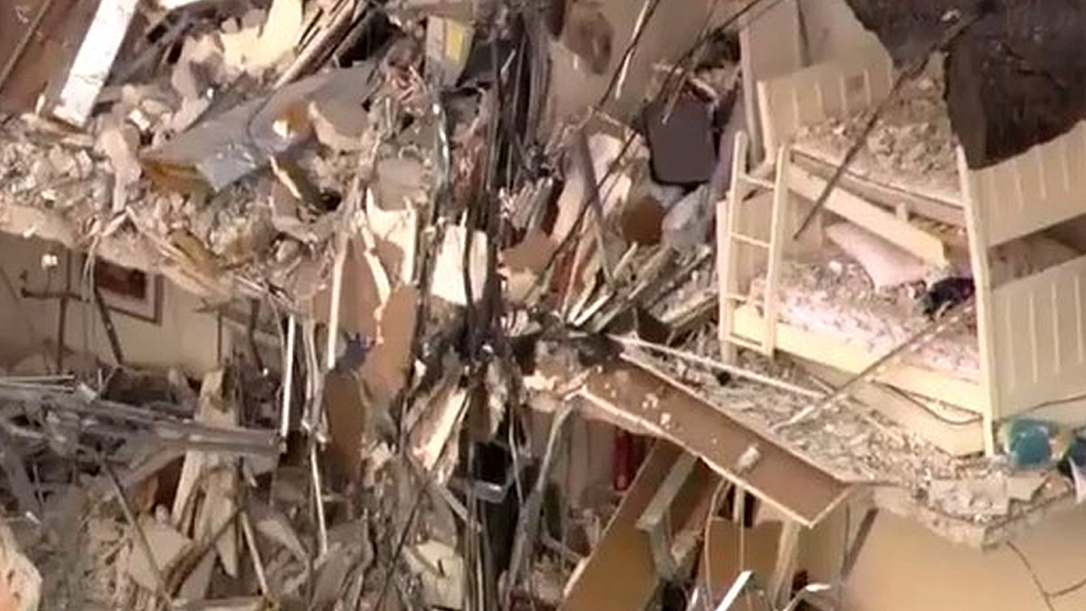 A bedroom is seen in part of the collapsed building.