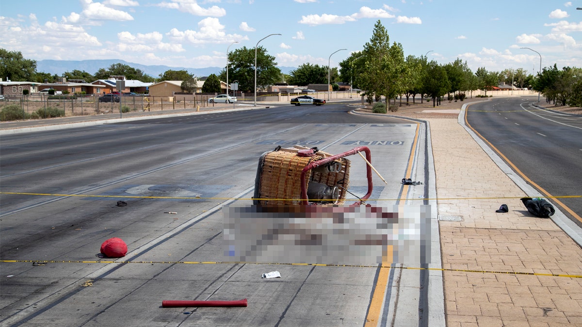 The basket of a hot air balloon which crashed lies on the pavement in Albuquerque, N.M., Saturday, June 26, 2021. Police said the five occupants died after it crashed on the busy street.