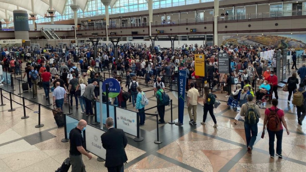 Travelers wait on line for a security screening at Denver International Airport. 