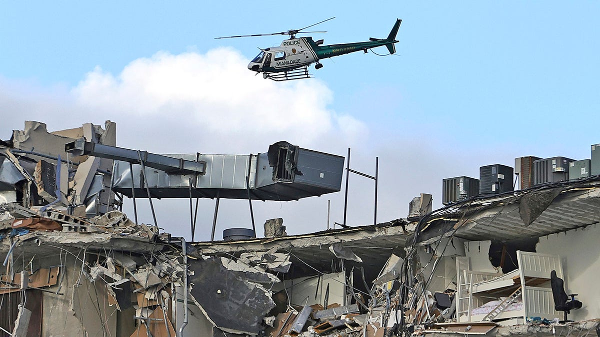 A Miami-Dade Police helicopter flies over the Champlain Towers South Condo after the multistory building partially collapsed, Thursday, June 24, 2021, in Surfside, Florida.?